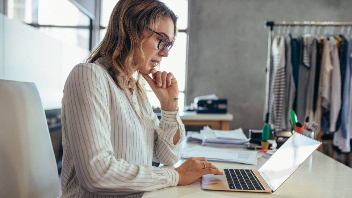 female business owner reviewing items on laptop